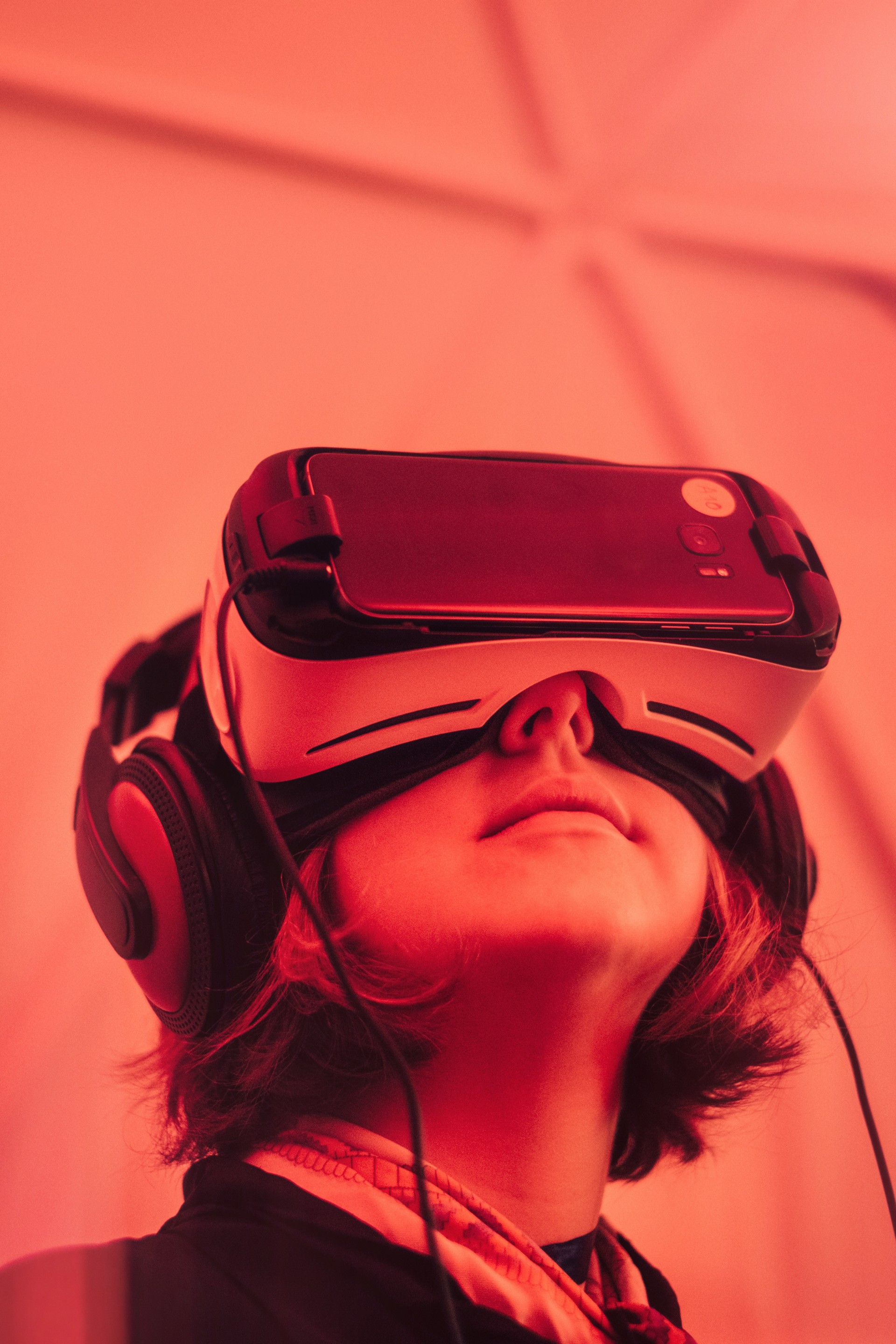 Red image of a young boy with headphones and virtual reality glasses